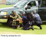 SWAT team behind police cars